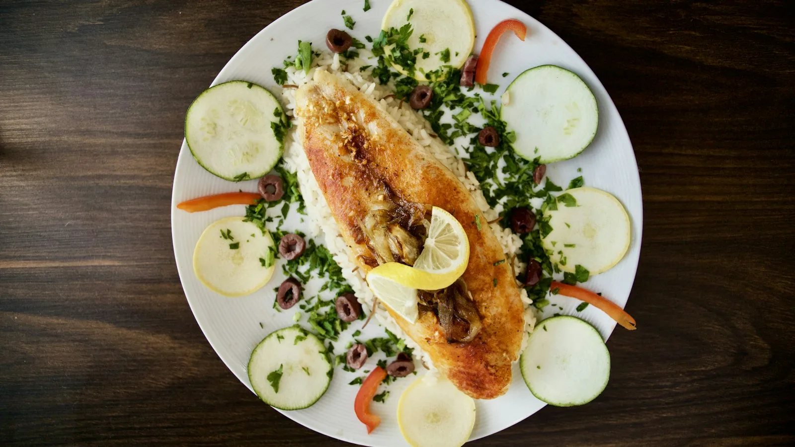 Table sicilienne avec poisson grillé, salade d'oranges et légumes, un repas naturellement sans gluten